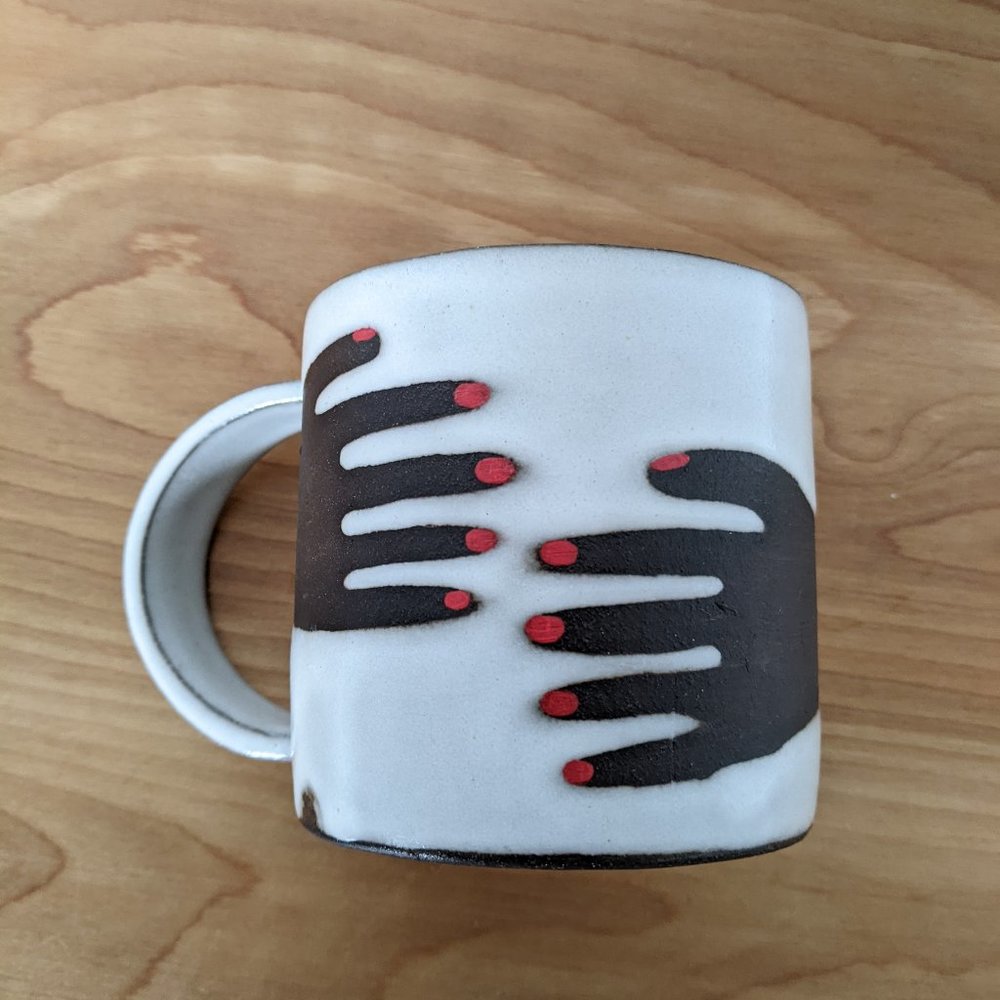 Martina Thornhill ceramic black hug mug with red nails